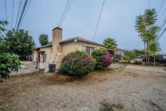 a view of a house with a yard and potted plants