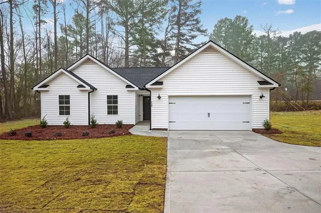 a view of a house with a yard and garage