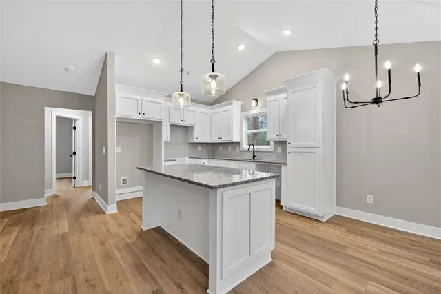 a kitchen with kitchen island a sink stove and wooden floor