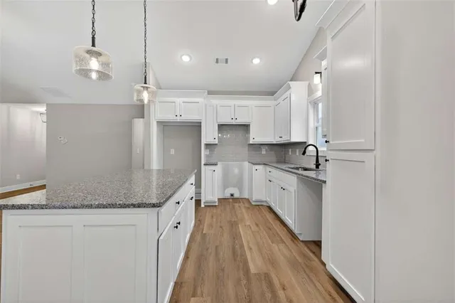 a large kitchen with a lot of counter space and wooden floor