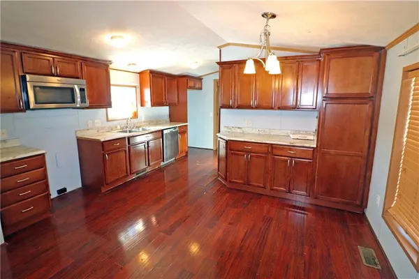 a kitchen with stainless steel appliances wooden floors and wooden cabinets