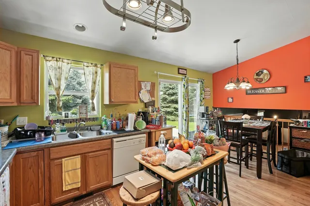 a very nice looking dining room with kitchen island furniture a large window and a sink