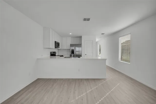 a view of kitchen with stainless steel appliances refrigerator sink and cabinets