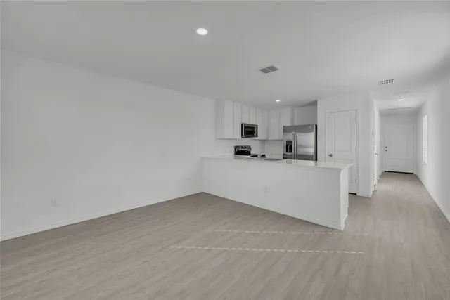 a view of kitchen with refrigerator and window