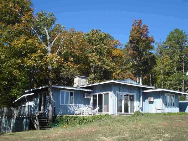 a view of a house with a yard and large trees