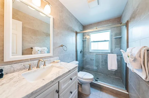 a bathroom with a granite countertop sink toilet and shower