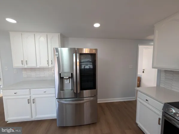 a kitchen with stainless steel appliances granite countertop a refrigerator and a stove top oven