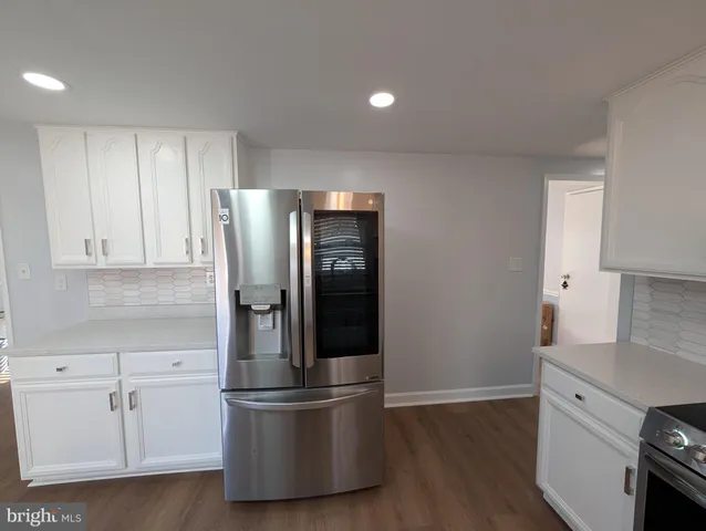 a kitchen with stainless steel appliances granite countertop a refrigerator and a stove top oven