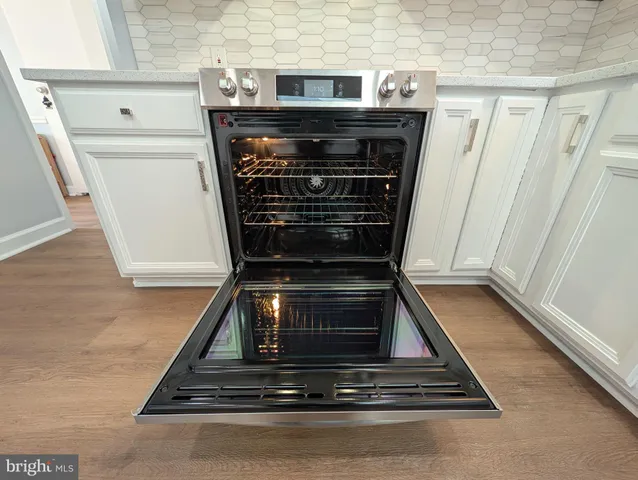 a stove top oven sitting inside of a kitchen
