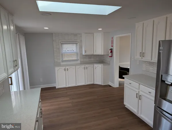 a kitchen with granite countertop white cabinets and stainless steel appliances