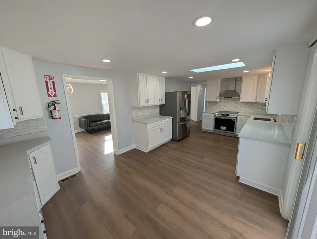 a kitchen with a refrigerator and a stove top oven