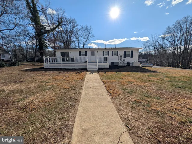 a front view of a house with yard and tree s
