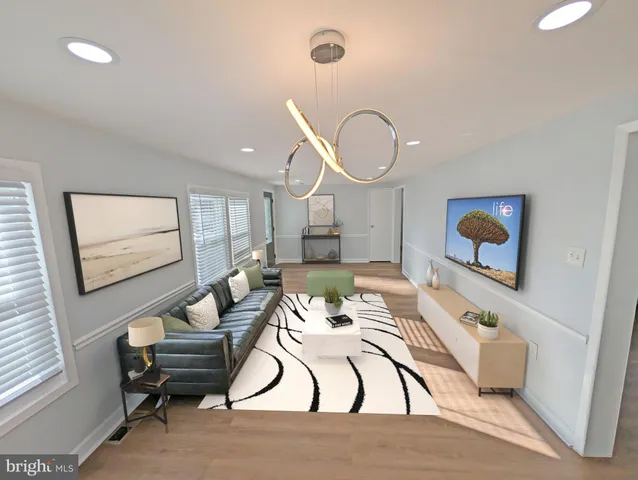 a living room with furniture a couch and wooden floor