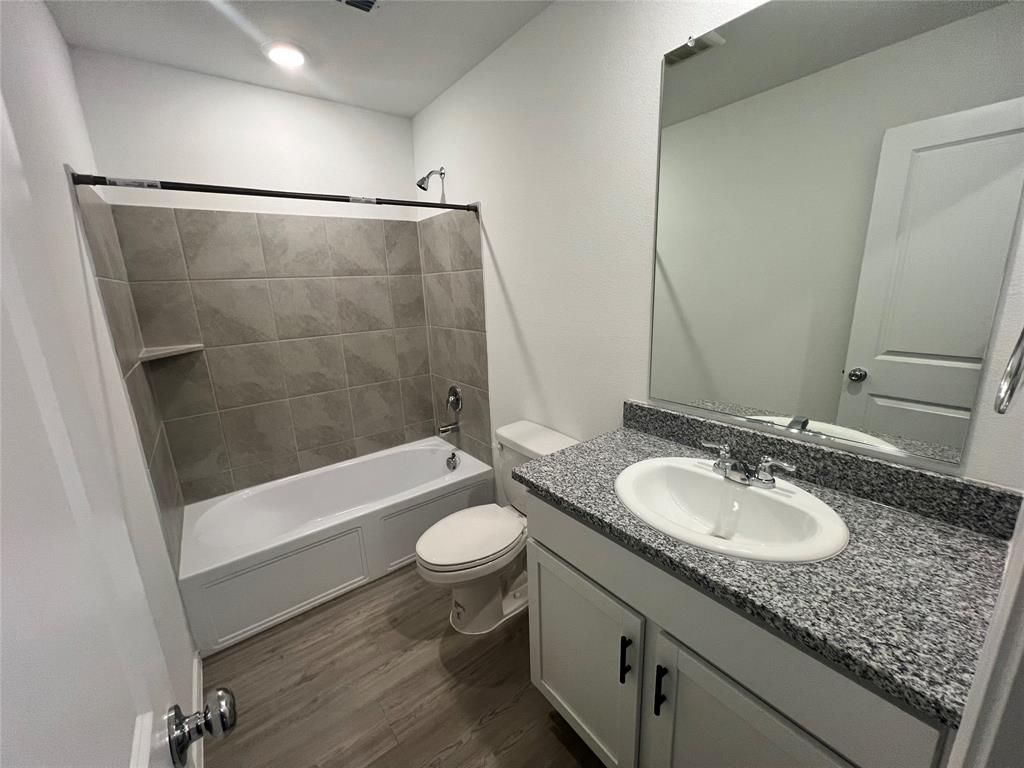 9012 Red Fox Trail McKinney, TX 75071 - Photo 16 of 35 a bathroom with a granite countertop sink toilet mirror and bathtub