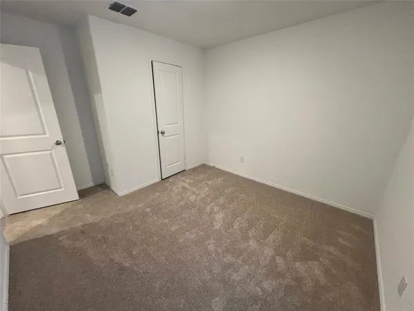 an empty room with chandelier fan