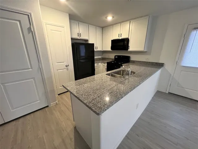 a kitchen with granite countertop a refrigerator and a sink