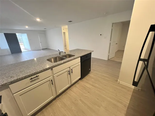 a kitchen with granite countertop white cabinets and a sink