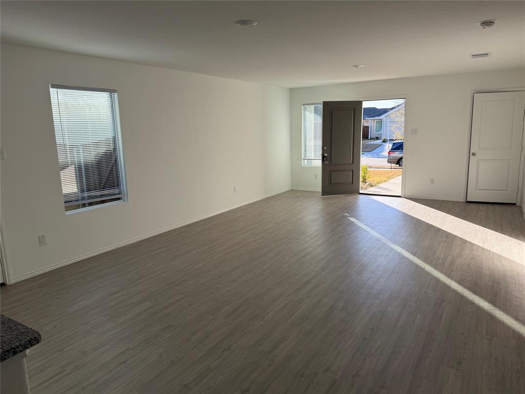 9012 Red Fox Trail McKinney, TX 75071 - Photo 7 of 35 an empty room with wooden floor and windows