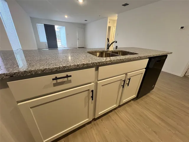 a kitchen with sink cabinets and wooden floor