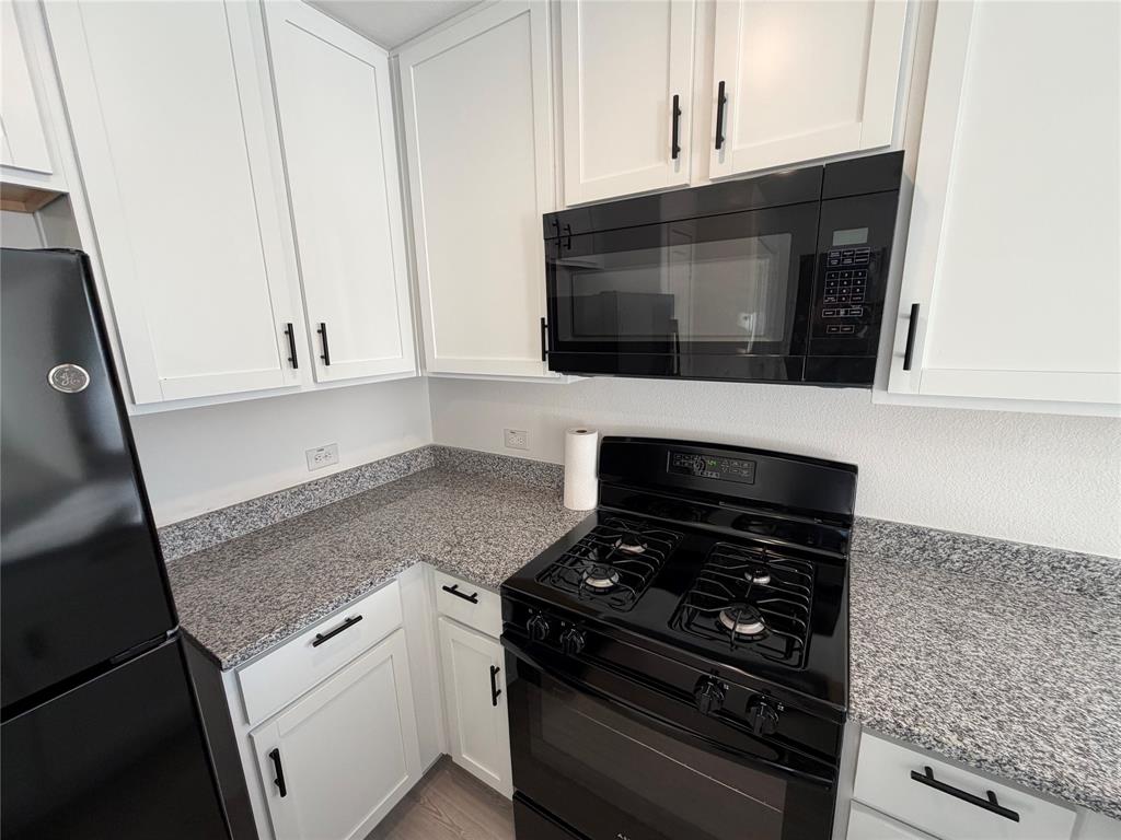 9012 Red Fox Trail McKinney, TX 75071 - Photo 9 of 35 a kitchen with granite countertop a stove and a microwave