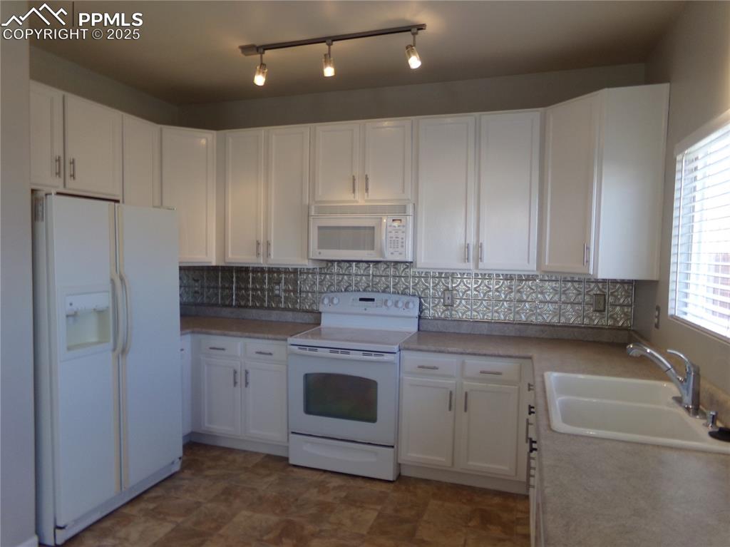 895 Rancher Drive Fountain, CO 80817 - Photo 11 of 29 a kitchen with a sink stove and cabinets