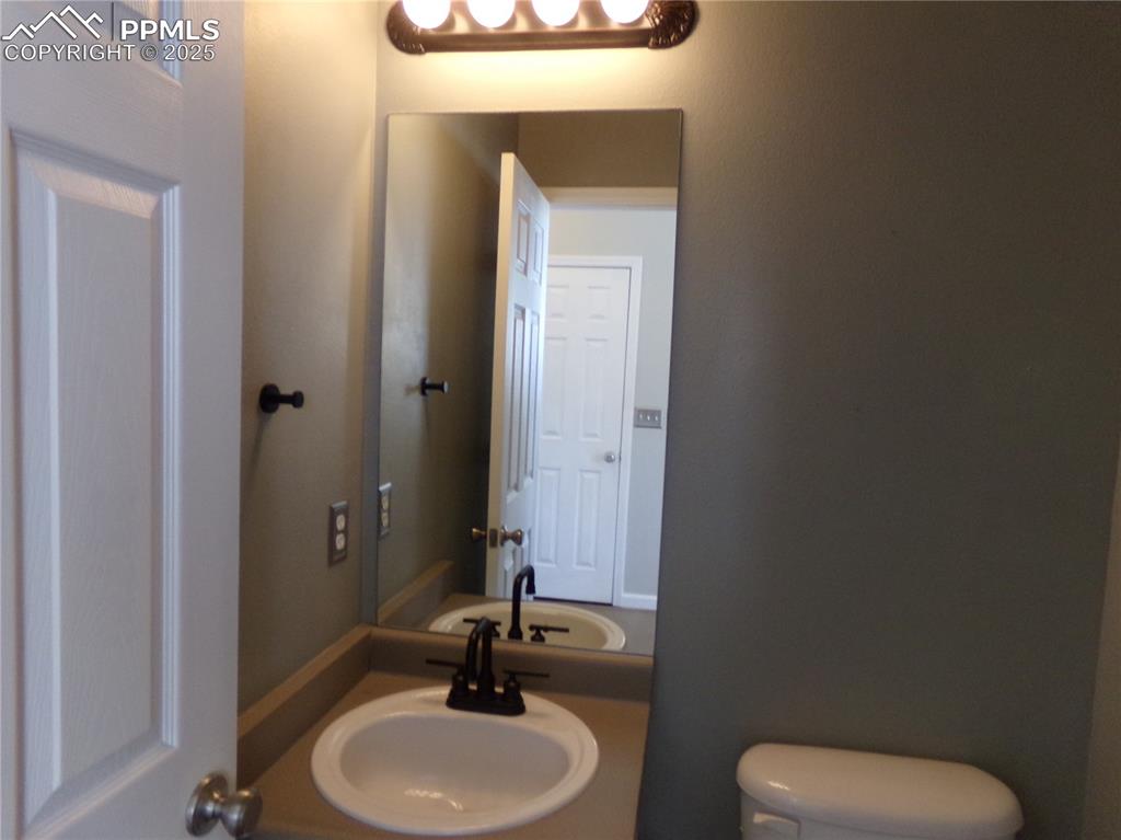895 Rancher Drive Fountain, CO 80817 - Photo 12 of 29 a bathroom with a toilet sink and mirror