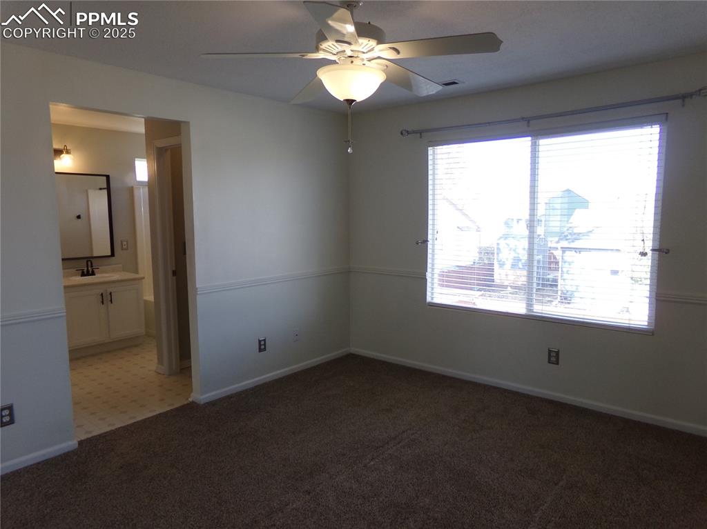 895 Rancher Drive Fountain, CO 80817 - Photo 16 of 29 en empty room with windows and chandelier fan