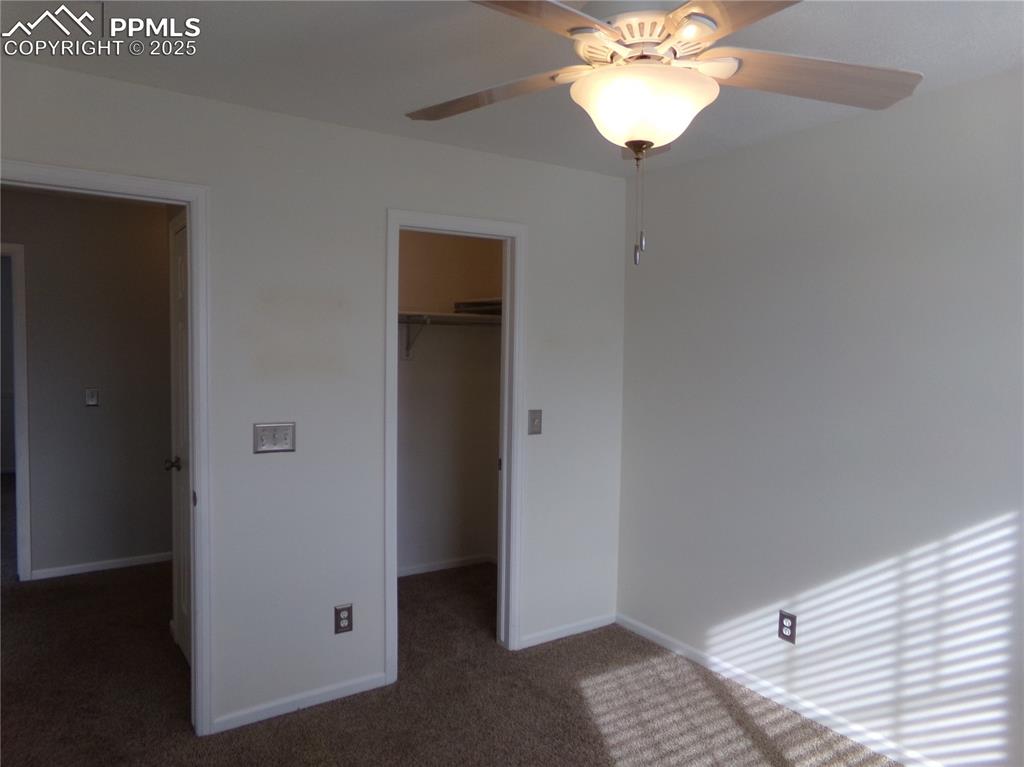 895 Rancher Drive Fountain, CO 80817 - Photo 22 of 29 a view of a hallway with a chandelier fan and wooden floor