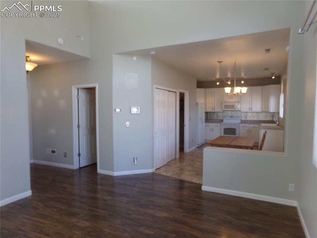 895 Rancher Drive Fountain, CO 80817 - Photo 7 of 29 a view of a hallway with wooden floor and a kitchen