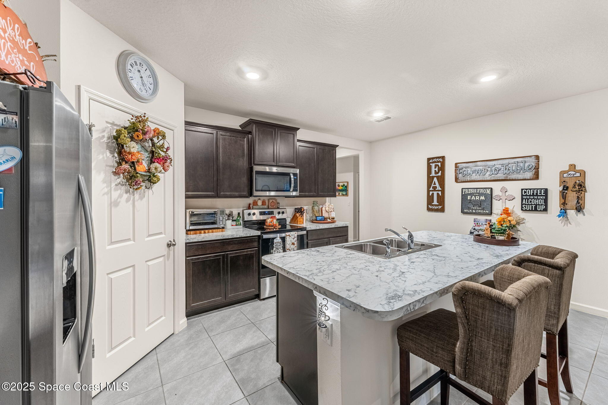 4901 Talbot Boulevard Cocoa, FL 32926 - Photo 12 of 39 a kitchen with granite countertop kitchen island stainless steel appliances a stove refrigerator sink and cabinets