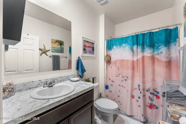 a bathroom with a sink toilet and shower curtain