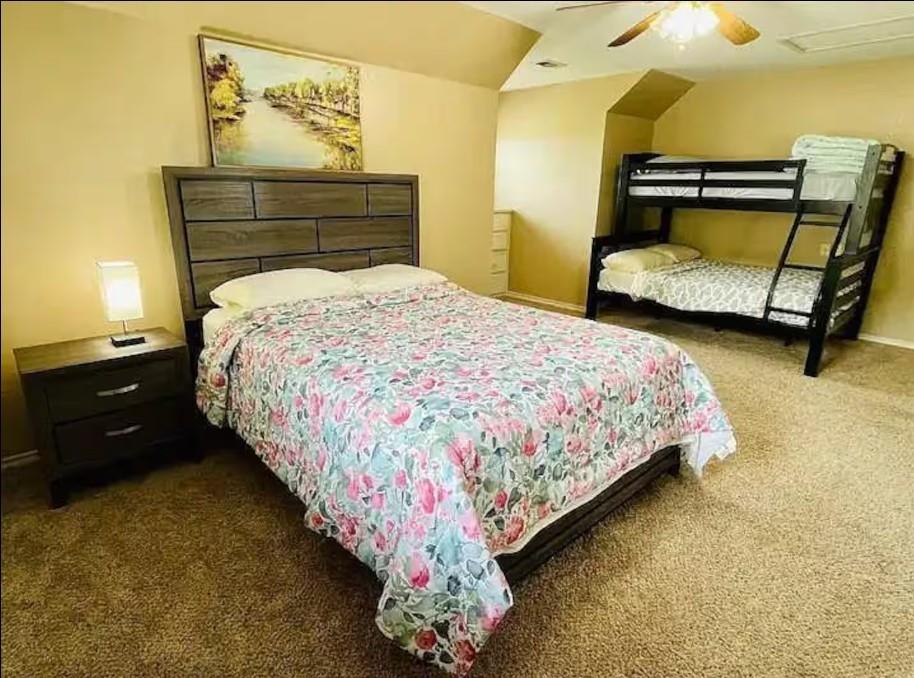 207 Emberson Chapel Road Pilot Point, TX 76258 - Photo 14 of 18 Carpeted bedroom featuring a textured accent wall, ceiling fan, and built-in dresser