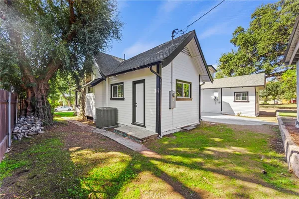 a view of a house with backyard and a tree