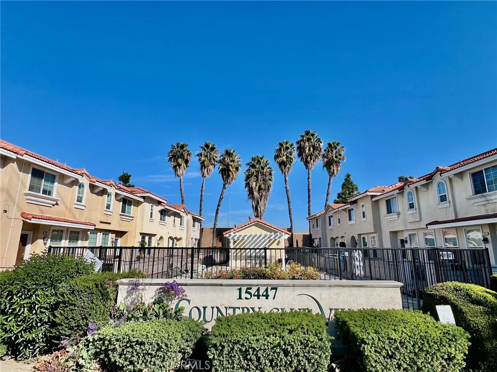 15447 Pomona Rincon Road, Unit 844 Chino Hills, CA 91709 - Photo 1 of 1 a large building with a tree in front of it