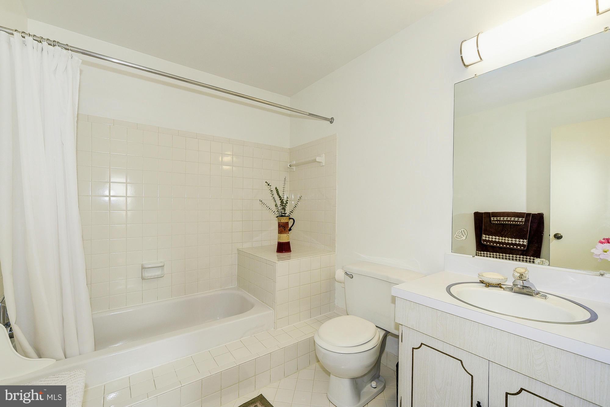 15013 Wellwood Road Silver Spring, MD 20905 - Photo 22 of 30 a bathroom with a sink toilet a mirror and shower