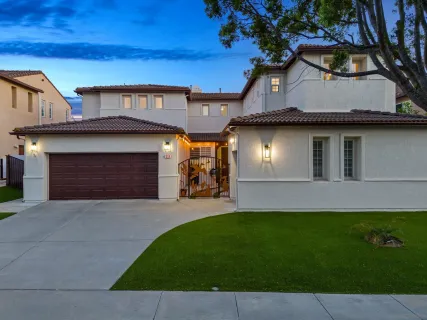 a front view of a house with a garden and yard