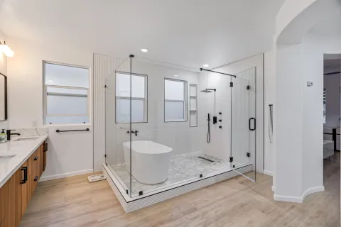 a spacious bathroom with a double vanity sink a mirror and a bathtub