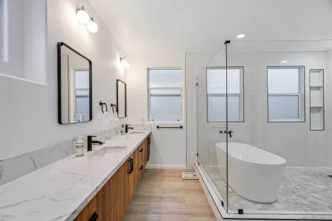 a spacious bathroom with a granite countertop sink a mirror and shower
