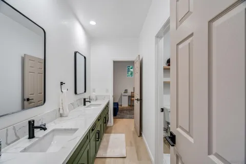 a en suite bathroom with a double vanity sink a mirror and shower