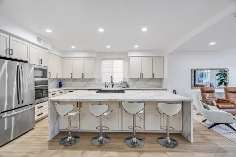 a kitchen with stainless steel appliances kitchen island a sink stove and refrigerator