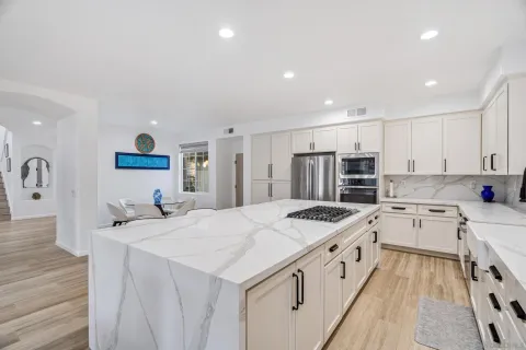 a large kitchen with stainless steel appliances granite countertop a lot of counter space and wooden floors