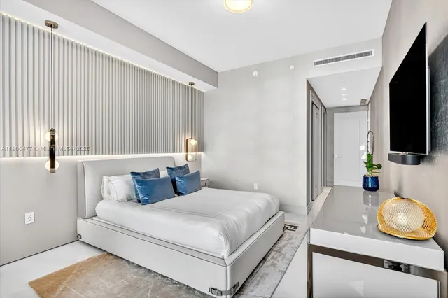 a bedroom with a bed and flat screen tv