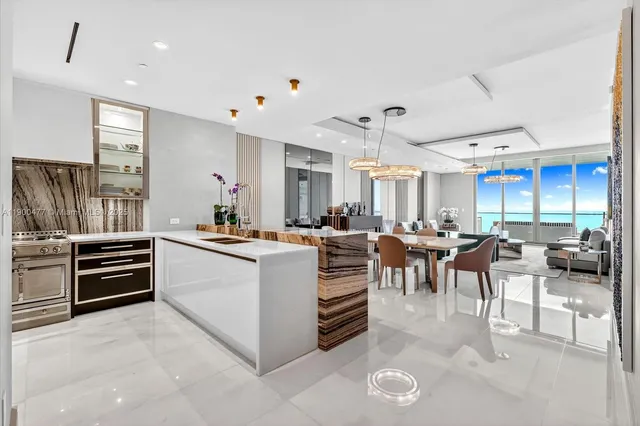 a large white kitchen with lots of counter space and furniture