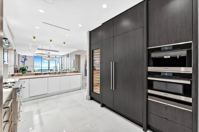 a large white kitchen with a refrigerator and a stove
