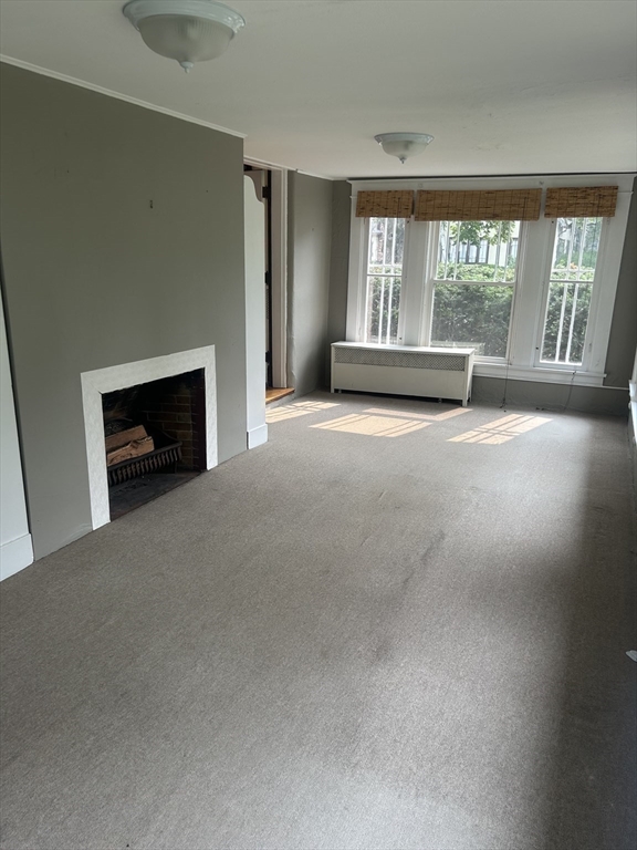 19 Wellesley Road Holyoke, MA 01040 - Photo 14 of 27 a view of an empty room with a fireplace and a window
