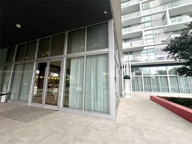 a view of a balcony with a potted plant and floor to ceiling window