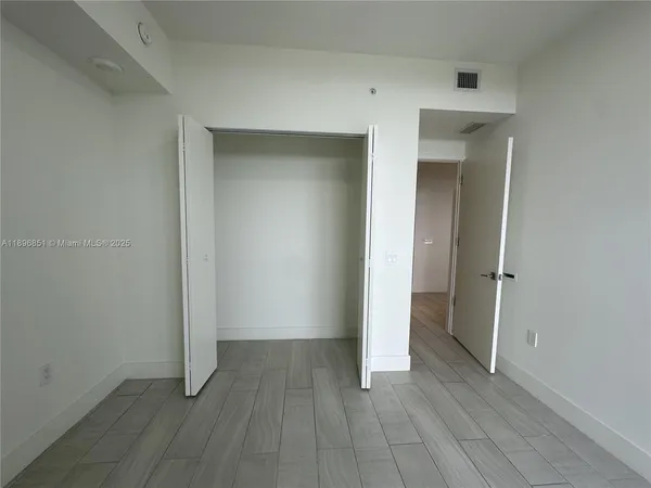 a view of an empty room and closet area