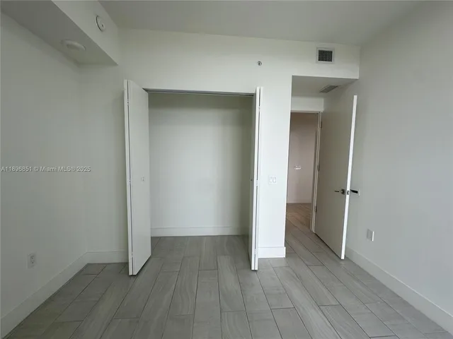 a view of an empty room and closet area