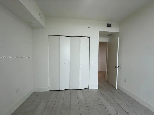 a view of an empty room with sliding glass door