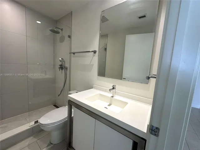 a bathroom with a sink a toilet and a shower